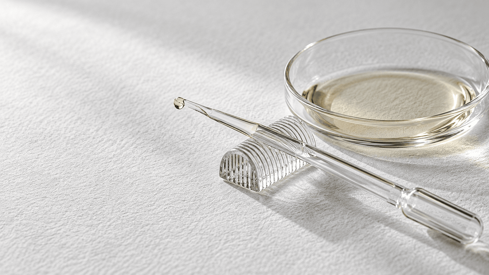 A glass pipette and a shallow oil study on textured paper